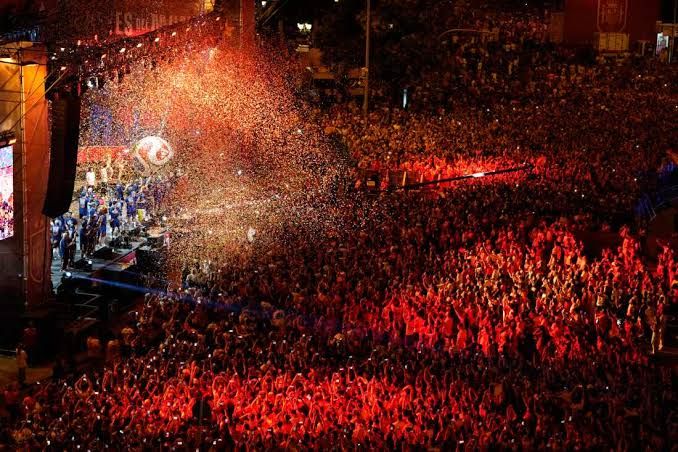 Spain national soccer team players celebrate on an open-top bus moving through crowded streets in Madrid.
