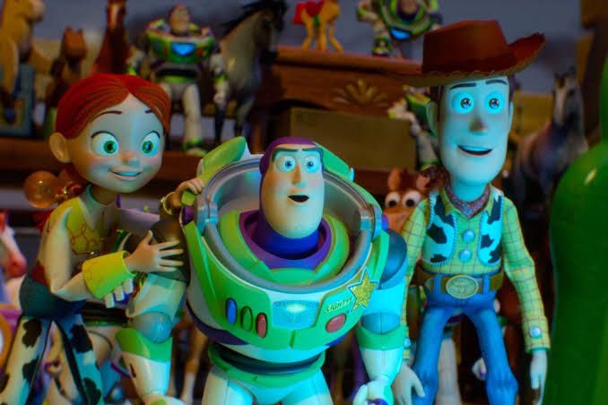 Woody, Buzz Lightyear, and Jessie from the movie Toy Story 5 standing together in a promotional scene.
