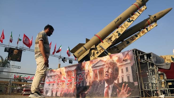 A man observes a large banner of Donald Trump next to Iranian ballistic missiles in Tehran.