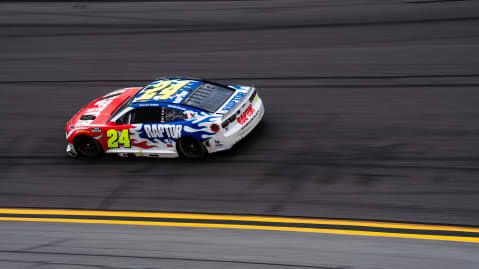 A NASCAR Cup Series car drives on the high-banked turns of Daytona International Speedway during a race event.