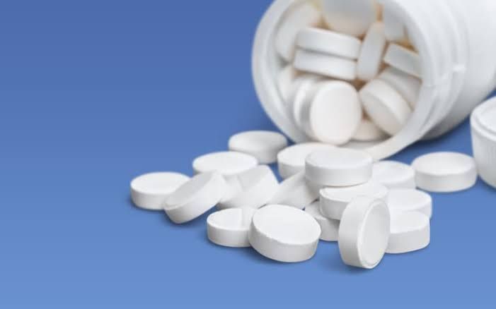 A clinical medical professional analyzing pill packaging in a clean, modern pharmacy setting.