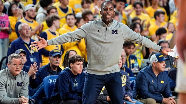 Mike Boynton Jr. coaching on the sideline during a Michigan basketball game.