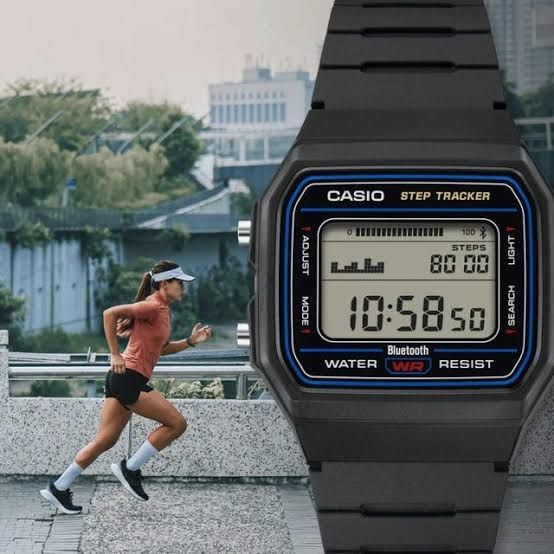Casio F-B100W digital watch with an LCD screen displaying a step count graph against a runner background.