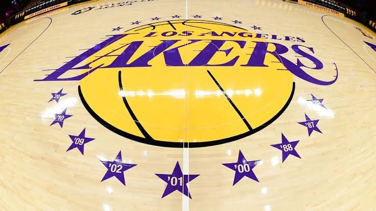 Lakers GM Rob Pelinka stands on the court during a press conference while discussing team personnel changes.