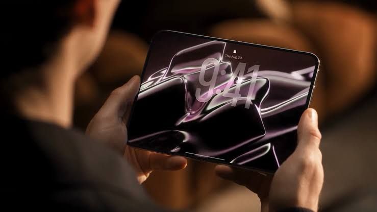 A digital rendering of a foldable iPhone with a large unfolded 7.8-inch display shown against a neutral studio background.