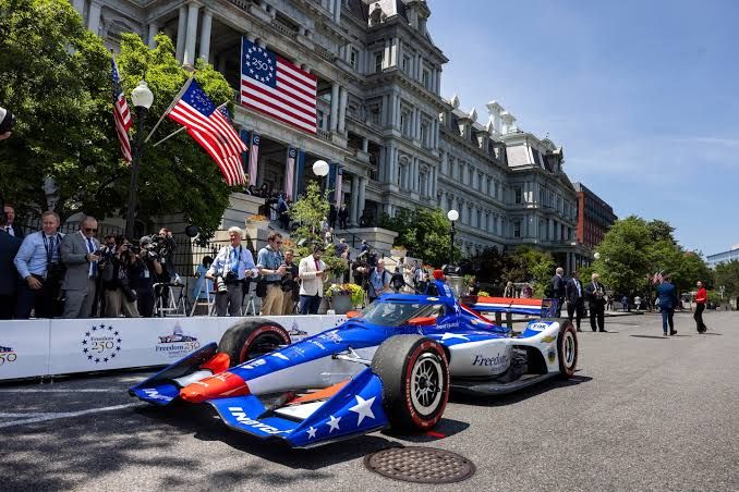 IndyCar pit crew performing a tire change near the White House and the Eisenhower Executive Office Building in D.C.