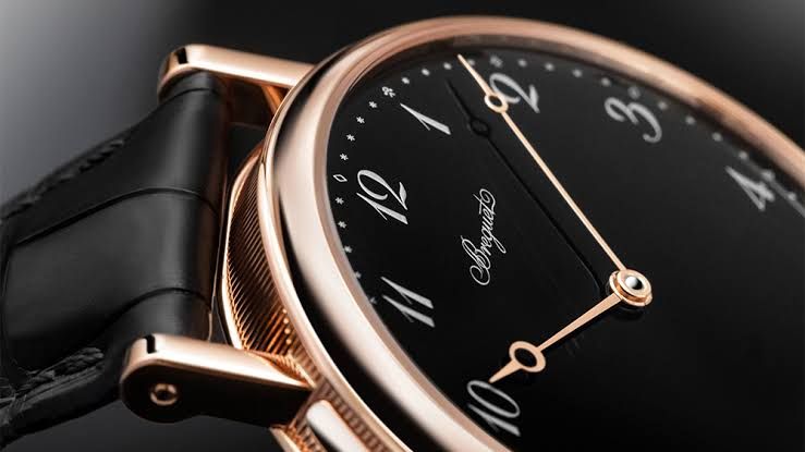 Close-up of a high-end Breguet watch dial next to a Samsung smartwatch displaying a digital replica of the face.