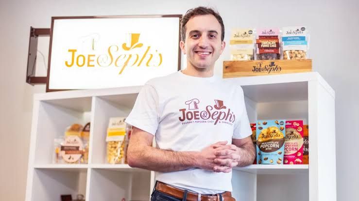 Adam Sopher stands in front of Joe and Seph's popcorn shelves, discussing the realities of manufacturing.