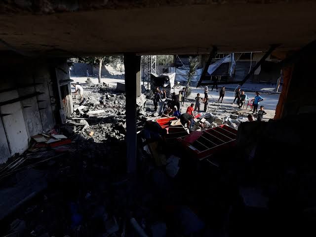 Palestinians search through debris after an Israeli airstrike in the Bureij refugee camp of the Gaza Strip.