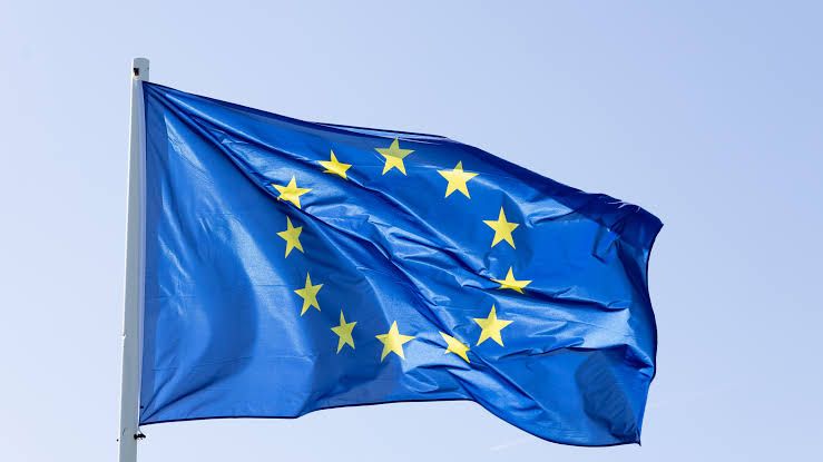 European Union flag waving in front of a blurred background, symbolizing recent legislative changes to electronics.