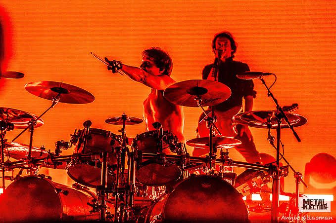 Mario and Joe Duplantier of Gojira performing on stage with their instruments.