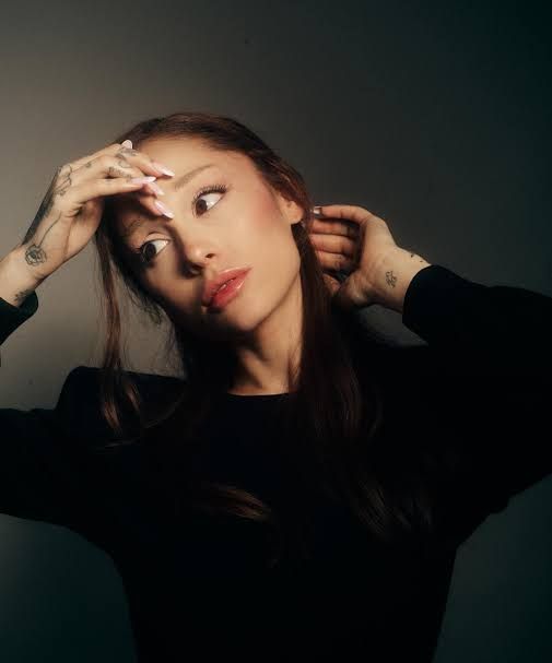 Ariana Grande looking at the camera for the cover art of her 2026 album titled Petal.
