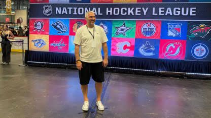 Alex Ovechkin posing in front of a large NHL event sign during his surprise appearance at Fanatics Fest in NYC.