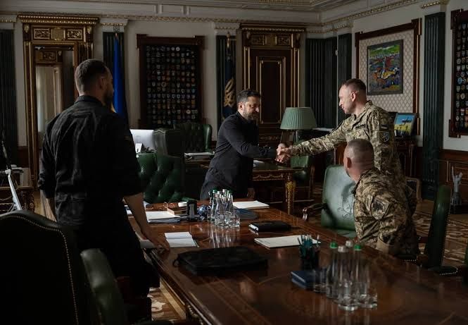 President Volodymyr Zelenskyy stands at a podium during a briefing on military leadership changes in Kyiv.