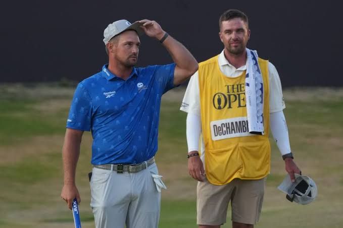 Bryson DeChambeau and his caddie discuss a rules penalty with an official at the British Open.