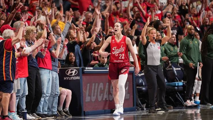 Caitlin Clark flexes after hitting a late game-winning shot for the Indiana Fever.