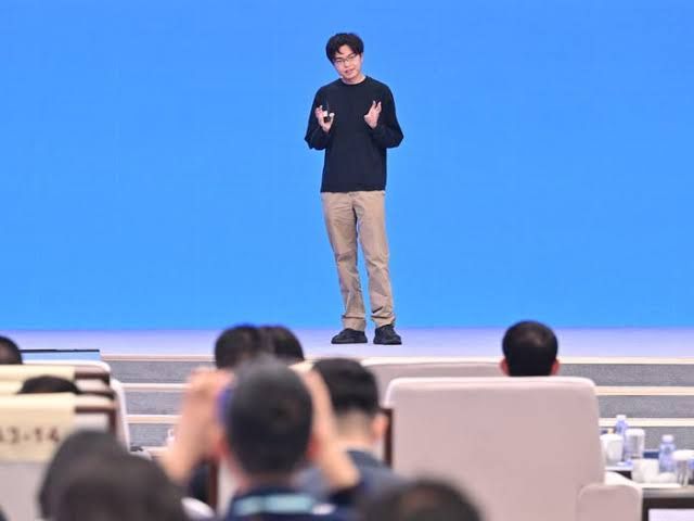 Yang Zhilin of Moonshot AI standing before a presentation screen detailing Kimi K3 capabilities.