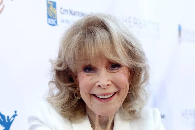 Barbara Eden smiling while attending a public event in a formal dress.