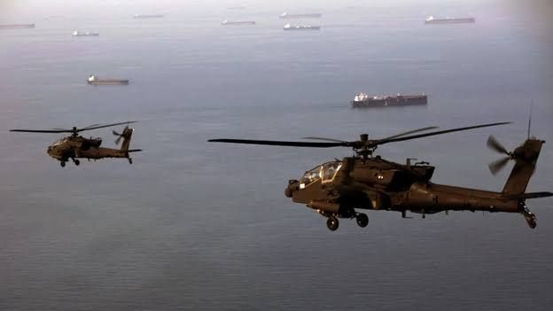 A U.S. sailor directs an MH-60S Sea Hawk helicopter on the deck of the USS Delbert D. Black in the Arabian Sea.