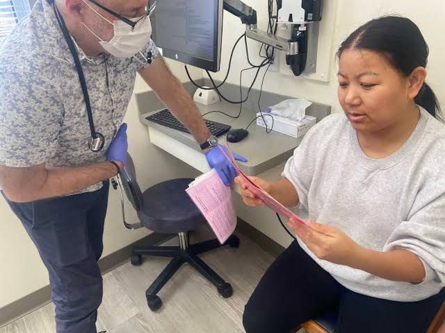 Pediatrician John Snyder consults with a patient and parent about vaccine information in his Massachusetts office.
