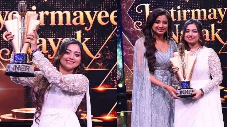 Jyotirmayee Nayak holding the Indian Idol 16 winner trophy on the singing reality show stage.