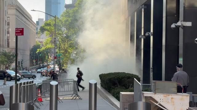 Heavy smoke plumes rise outside 26 Federal Plaza in New York City after an incendiary device explosion.