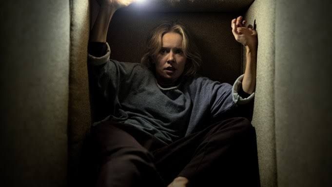 Amelia Eve stars in a scene from Insidious: Out of the Further where she encounters supernatural forces in a dark setting.