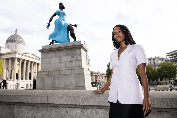 Artist Tschabalala Self stands beside her bronze sculpture Lady in Blue on the Fourth Plinth in London.