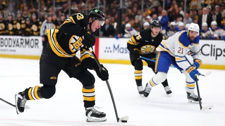 Forward Fraser Minten skating on the ice in a Boston Bruins jersey during an NHL game.
