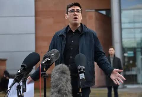 Andy Burnham wearing a dark navy shirt and trousers while arriving at a campaign event in Manchester.