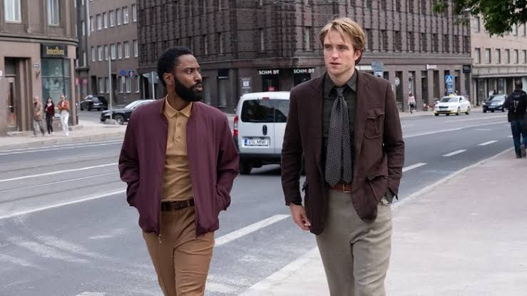 The Protagonist and Neil walking down a city street in a scene from the film Tenet.