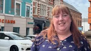 Emma Walton standing outside in Brackley, Northamptonshire, near a brick building during an interview.