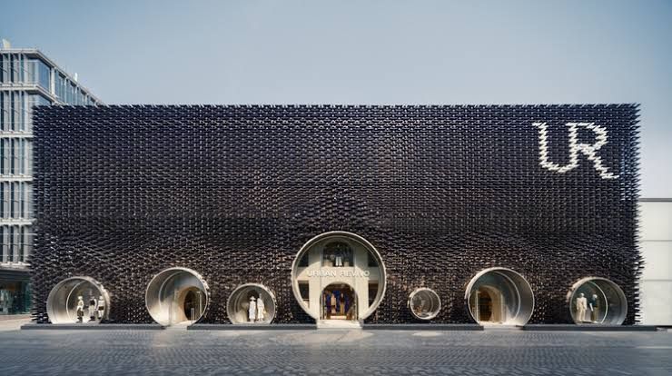 Exterior facade of the Urban Revivo flagship store in Beijing featuring dichroic blue aluminum tiles and moon gates.