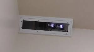 A digital monitoring box mounted on a wall with active lights used for tracking patient vitals in a healthcare facility.
