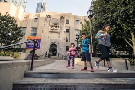 Exterior of the art deco Los Angeles Central Library during a clear day with city buildings in the background.