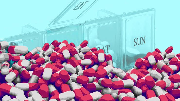 An elderly person looking at a large collection of prescription medication bottles on a table in their home.