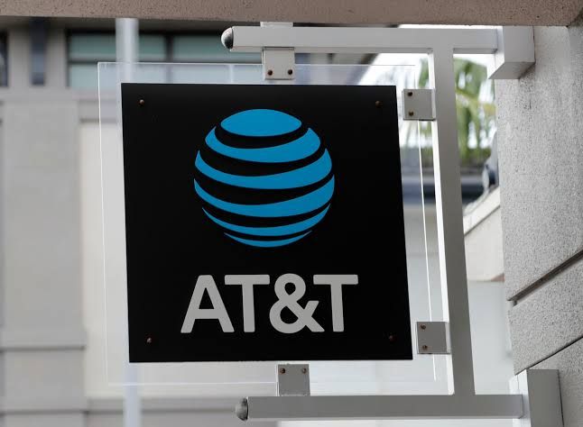 AT&T sign displayed at a local retail store in Portland as technicians work on nearby utility infrastructure.