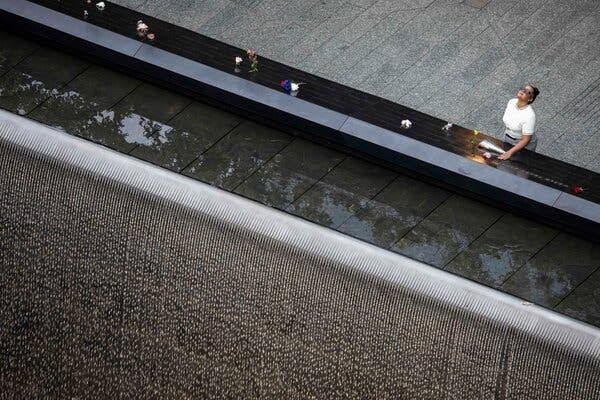 Family members gather at the 9/11 Memorial reflecting pools in New York City during the 25th-anniversary ceremony.