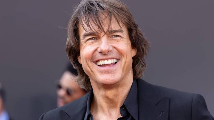 Tom Cruise holds an IMAX movie ticket for The Odyssey at the film's New York premiere.
