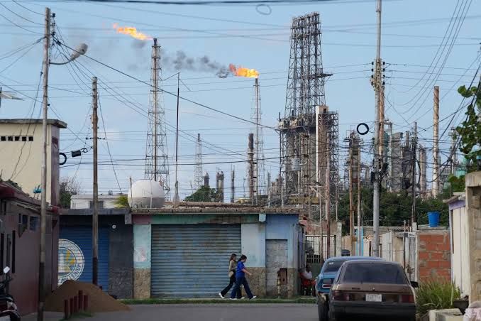The Amuay refinery in Venezuela, showing industrial infrastructure and storage tanks under a cloudy sky.
