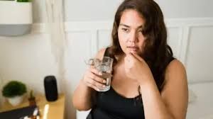 A woman holding a prescription pill bottle in her hand as part of an obesity and diabetes treatment study.
