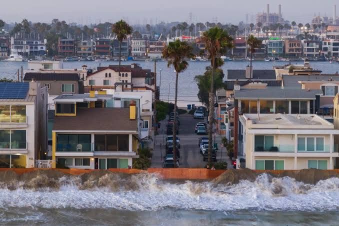 Long Beach city workers build a sand berm on the beach to prevent flooding from high tides and heavy surf.