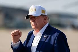 President Donald Trump walking on an airfield as he prepares to board a transport plane.