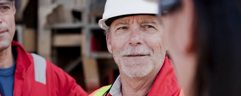 A construction worker reviewing plans on a site, representing the need for careful long-term financial planning.
