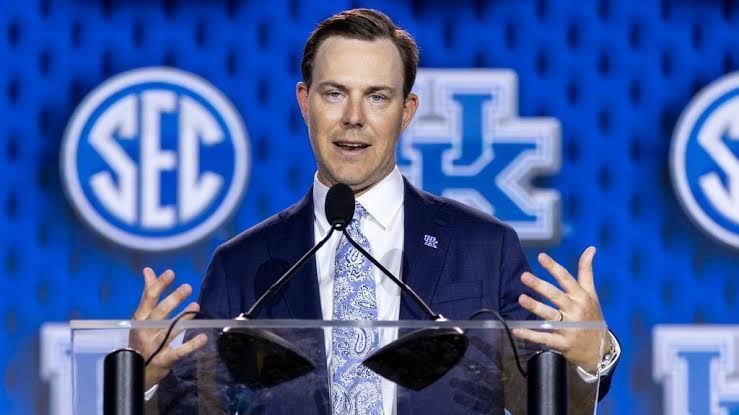 Kentucky head coach Will Stein speaking at the podium during SEC media days in Tampa.