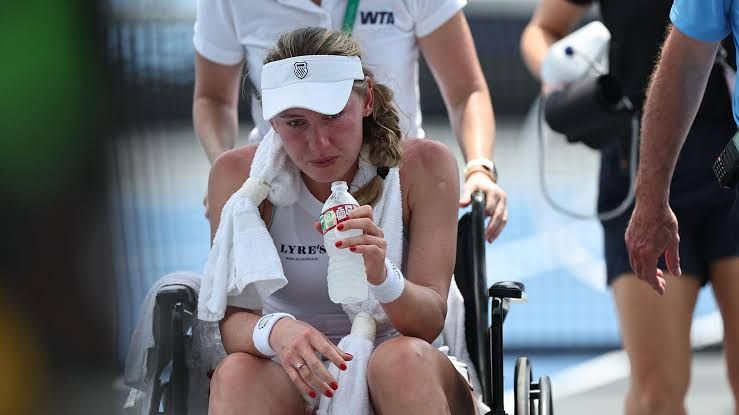 Ekaterina Alexandrova appearing distressed on the court before being assisted off by medical staff.