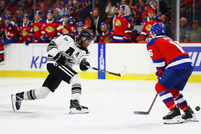 Bill Zonnon of the Blainville-Boisbriand Armada shoots the puck while defended by Tommy Bleyl during a QMJHL playoff game.