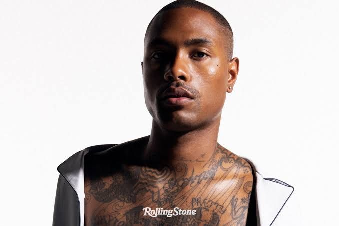 Steve Lacy looks down while writing in a notebook in a studio setting, reflecting his deep focus on songwriting.