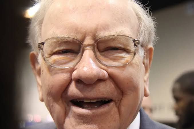 Warren Buffett sitting in a boardroom, representing his long-term investment philosophy during market uncertainty.