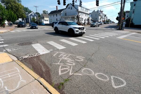 Mourners place flowers near the blood-stained pavement where Johan Sebastián Durán Guerrero was fatally shot by ICE agents.